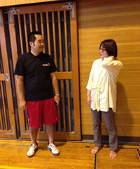 体育館にて、学校や家庭の侯さんの様子を互いに報告し合う担任の山崎先生（左）と川畑さん